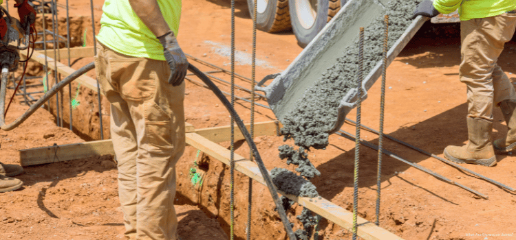 A man on a construction site holding and using a Concrete Vibrator
